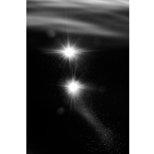 Photo artistique des reflets de la lumière sur l'eau et des constellations en noir et blanc, par Laurent Laporte